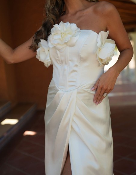 Longue robe blanche avec fente latérale et détails floraux