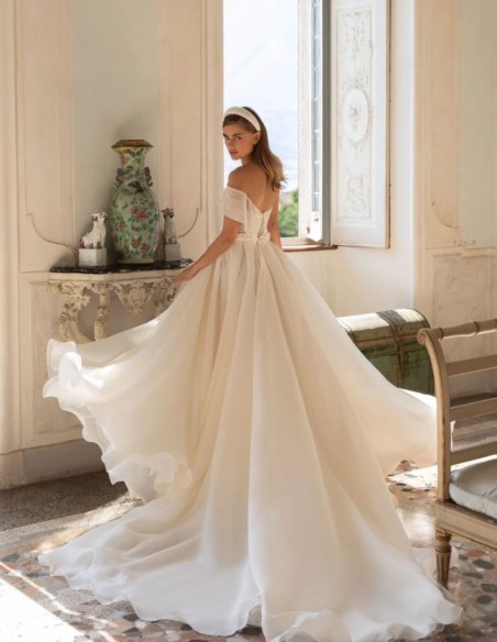 Robe de mariée avec encolure asymétrique et jupe fendue sur le côté