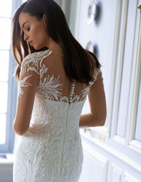 Vestido de novia con manga efecto tatuaje bordado y cola voluminosa precioso