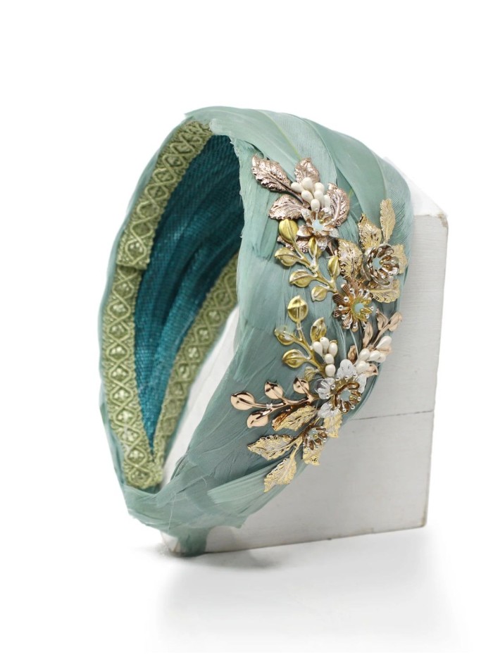 Diadema con base de plumas y detalle de joya...