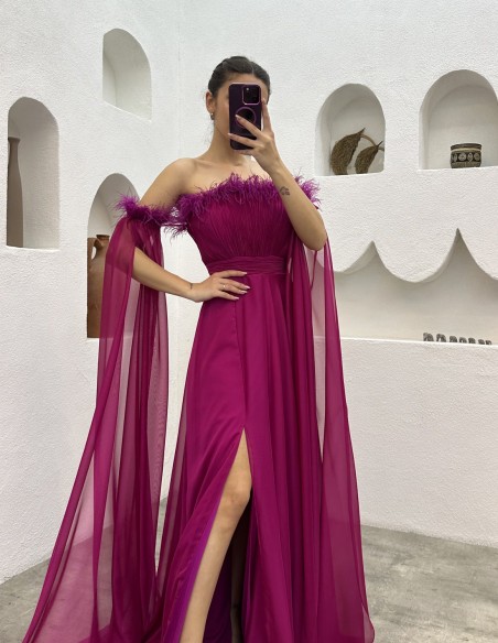 Vestido largo de fiesta con detalle plumas y manga capa fucsia