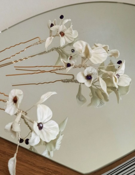 White bridal hairpins with flowers and rhinestone details.