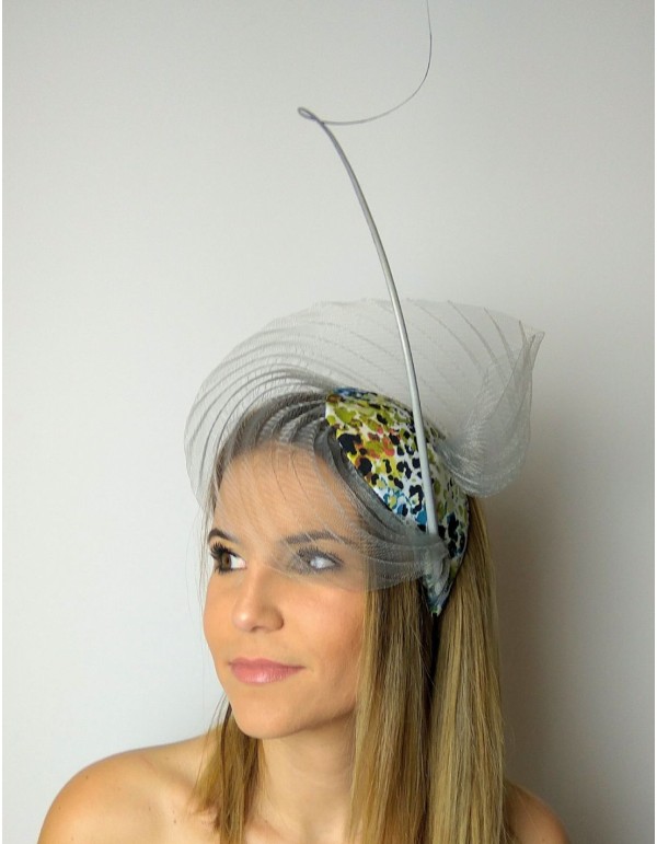 Tocado de invitada con base plisada gris confeccionado con tejido de animal print.
