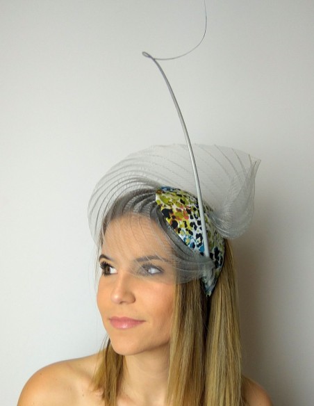 Tocado de invitada con base plisada gris confeccionado con tejido de animal print.