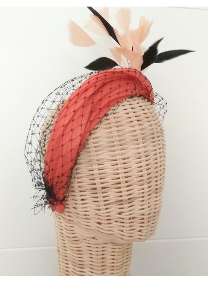 Orange guest headband with black feathers.