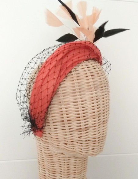 Orange guest headband with black feathers.