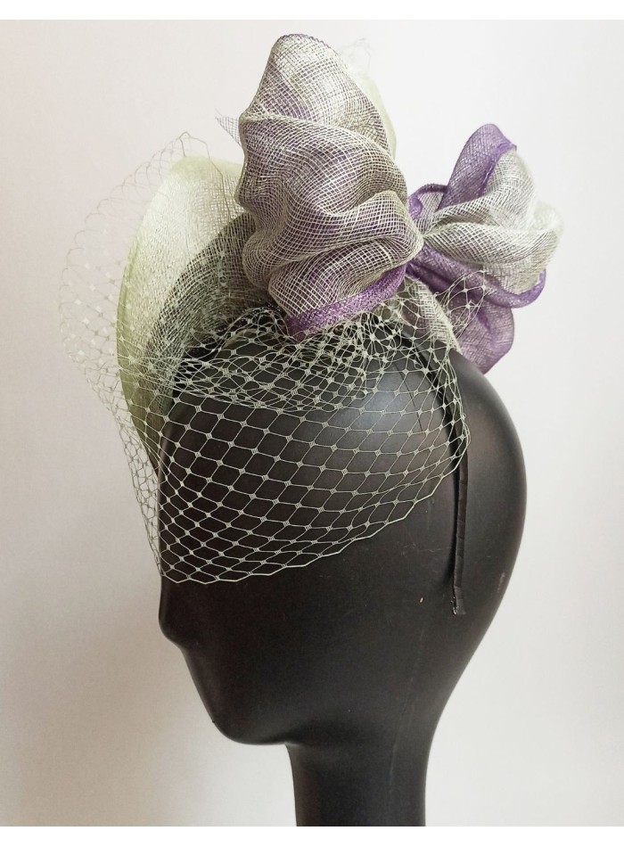 Veiled guest headpiece with raffia details.