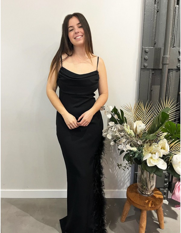 Vestido largo de fiesta con plumas en la abertura.