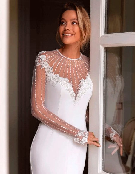 Vestido de novia con espalda infinita con transparencias y manga de encaje con pedrería