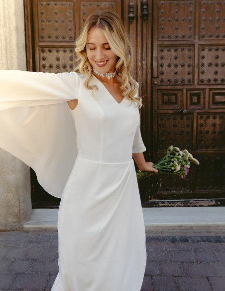 Cocktail dress with asymmetric french sleeves and cape