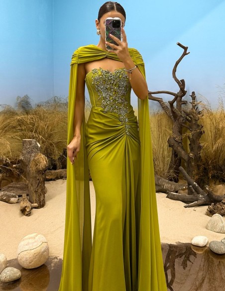 Vestido de fiesta con escote de pedrería, detalle de drapeado y capa